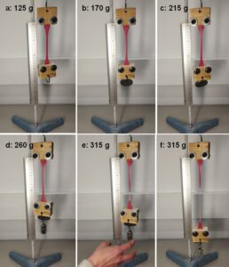 Figure 2. DIY tensile test setup with increasing weight applied to the lower grip. 