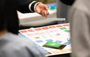 Figure 2: Composite photographs of the students playing their games in class. One game was a boardgame with 3-d printed tokens printed by the students and the other was more of a card game with tokens. 